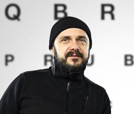 Arkadiusz Jakubik w dynamicznej pozie, sugerującej jego wszechstronność artystyczną.