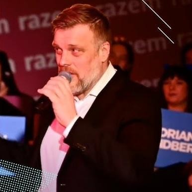 Adrian Zandberg podczas pracy, analizujący dokumenty w swoim gabinecie.