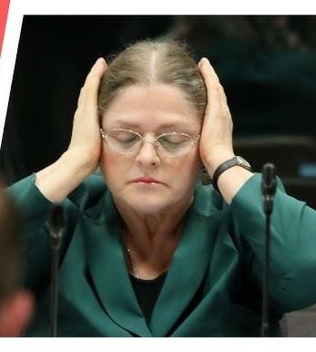 Krystyna Pawłowicz w swoim gabinecie, studiująca dokumenty prawne.