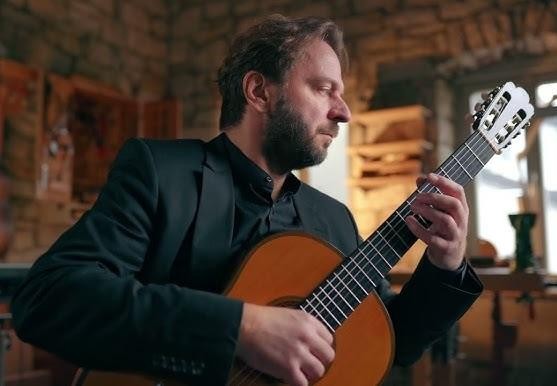 Zbliżenie na dłonie gitarzysty klasycznego podczas gry na instrumencie