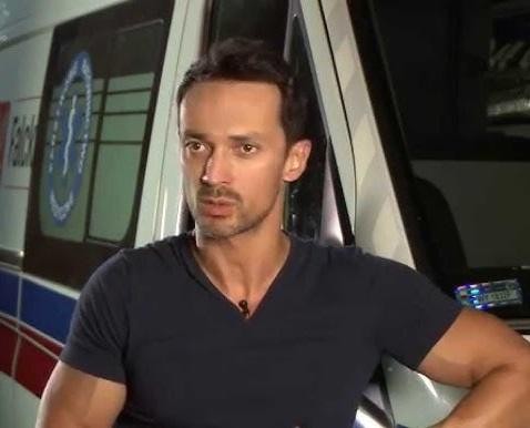 Rafał Cieszyński w dynamicznej scenie aktorskiej z serialu lub filmu.