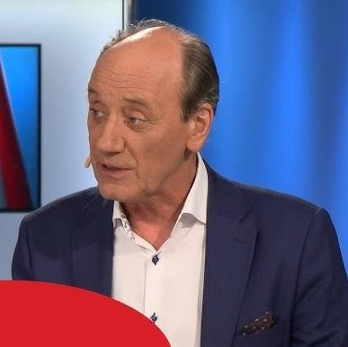 Mikrofon TVP Sport na tle stadionu piłkarskiego.