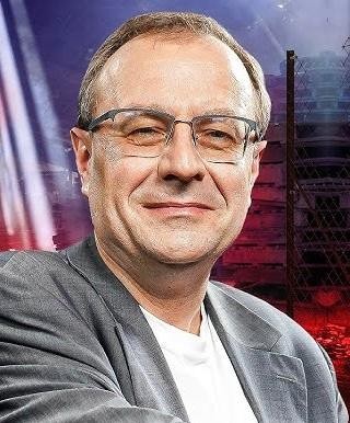 Dłonie profesora Antoniego Dudka na tle książek historycznych.