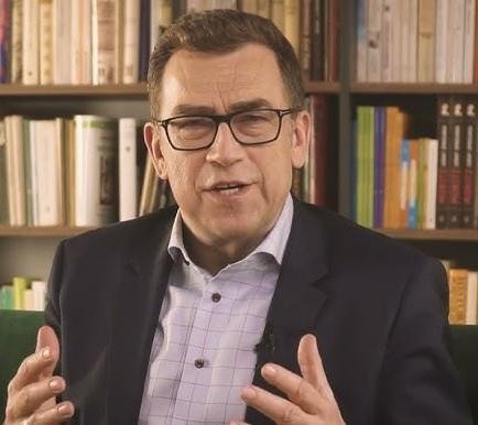 Maciej Orłoś na tle symbolizującym jego karierę aktorską i dziennikarską.