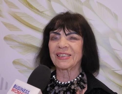 Sława Przybylska śpiewająca na scenie z mikrofonem, w stylowej kreacji.